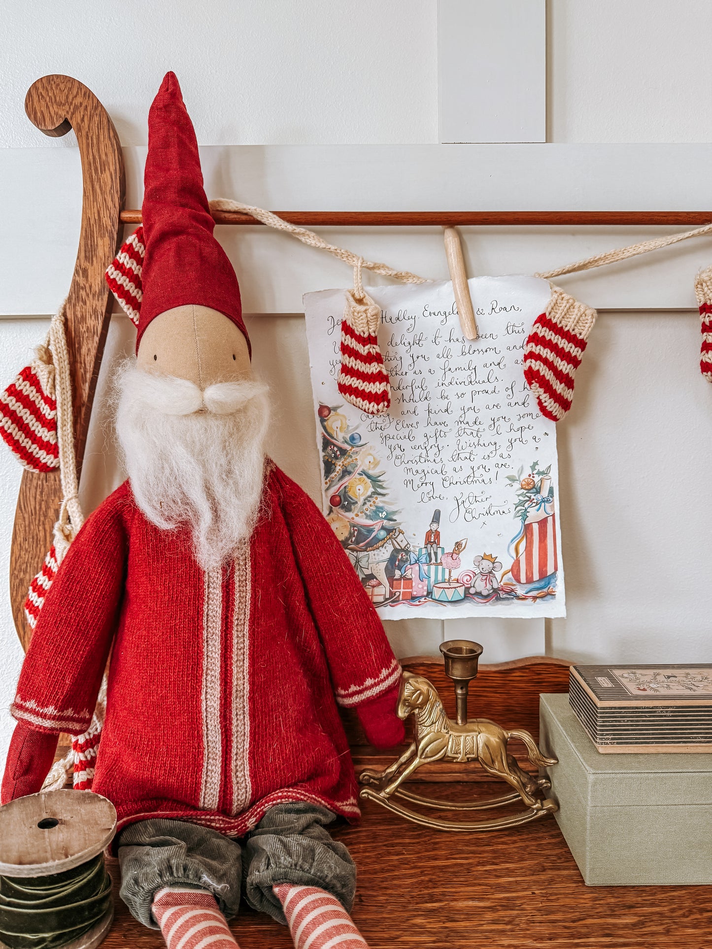 Red gnome figure with a letter and Christmas decorations on a shelf