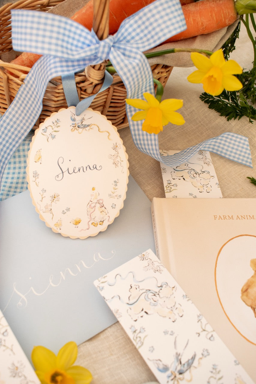 Easter-themed basket with carrots, flowers, and decorative items on a textured surface.