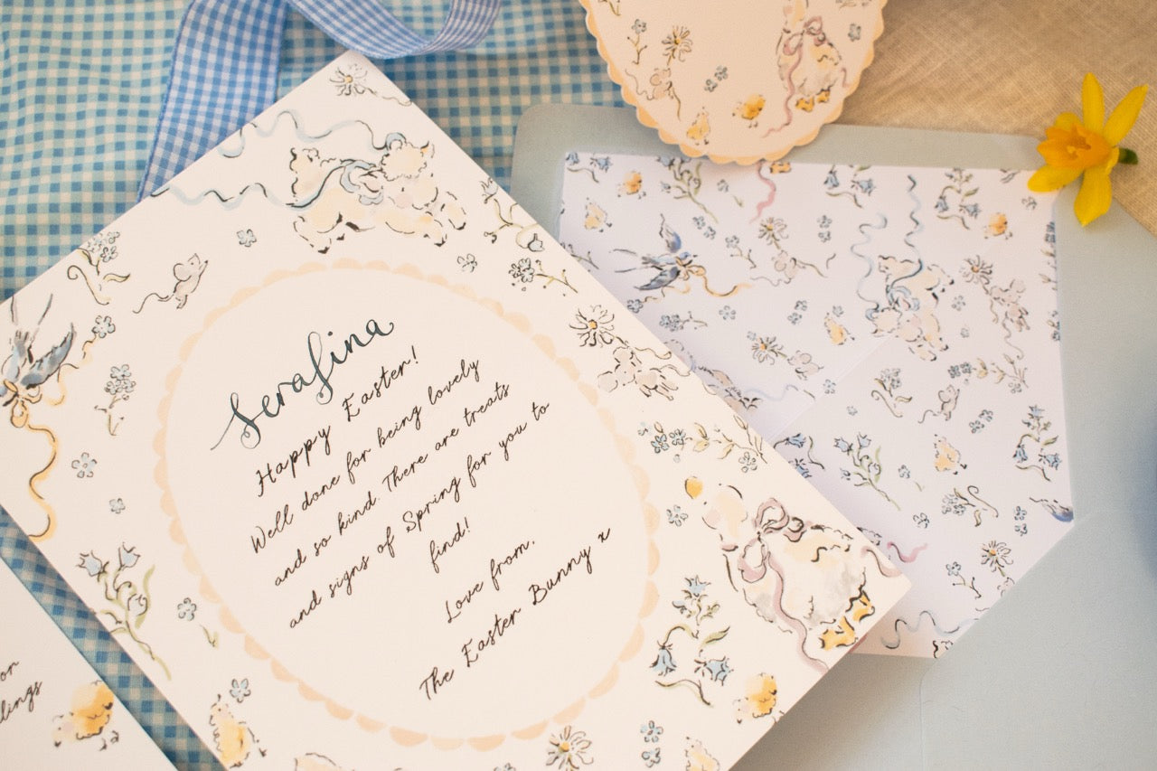 Decorative Easter cards with floral and bunny designs on a checkered fabric background.