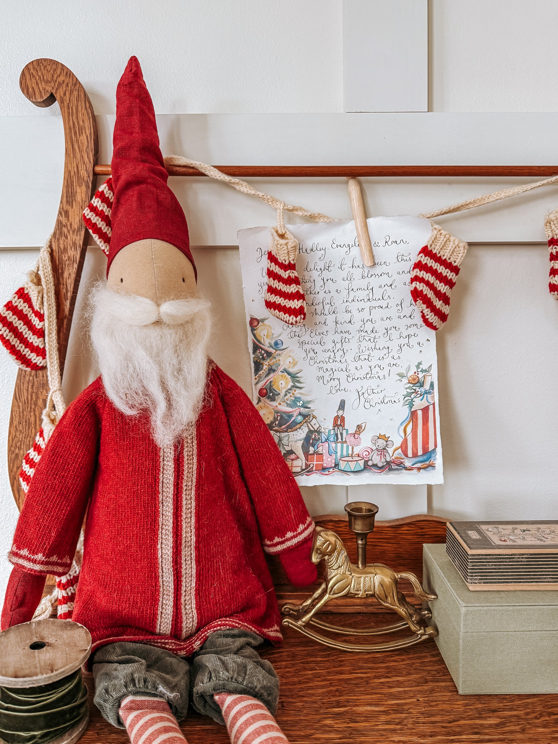 Red gnome figure with a letter and Christmas decorations on a shelf