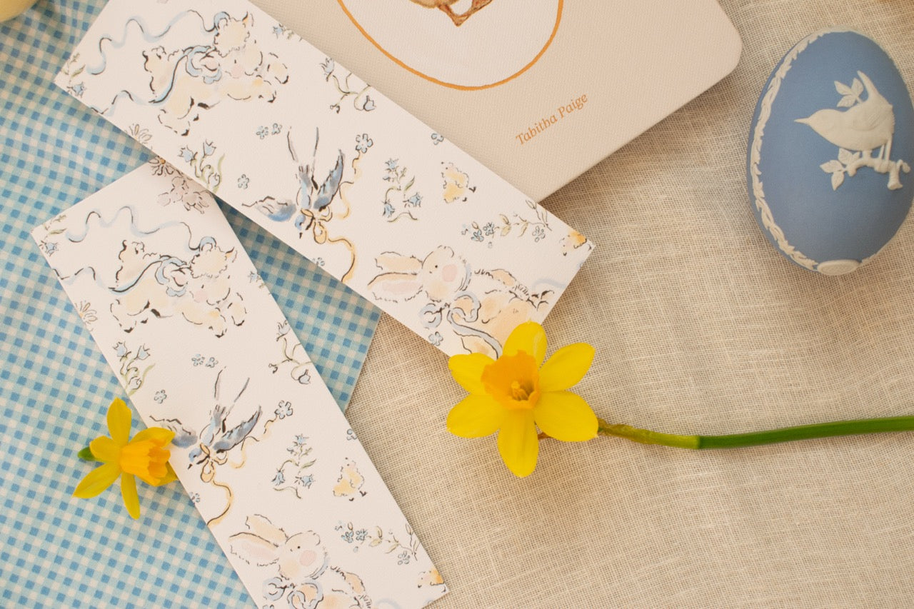 Decorative paper with bird and floral patterns on a textured surface with a yellow flower.