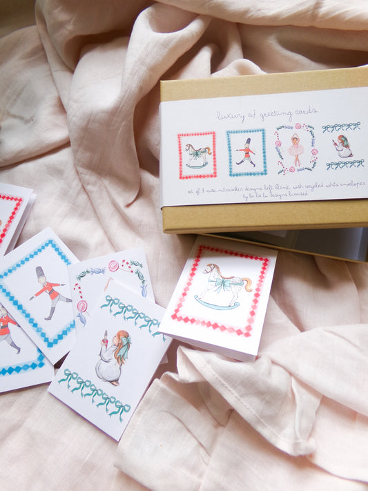 Set of illustrated cards and a box on a soft fabric background