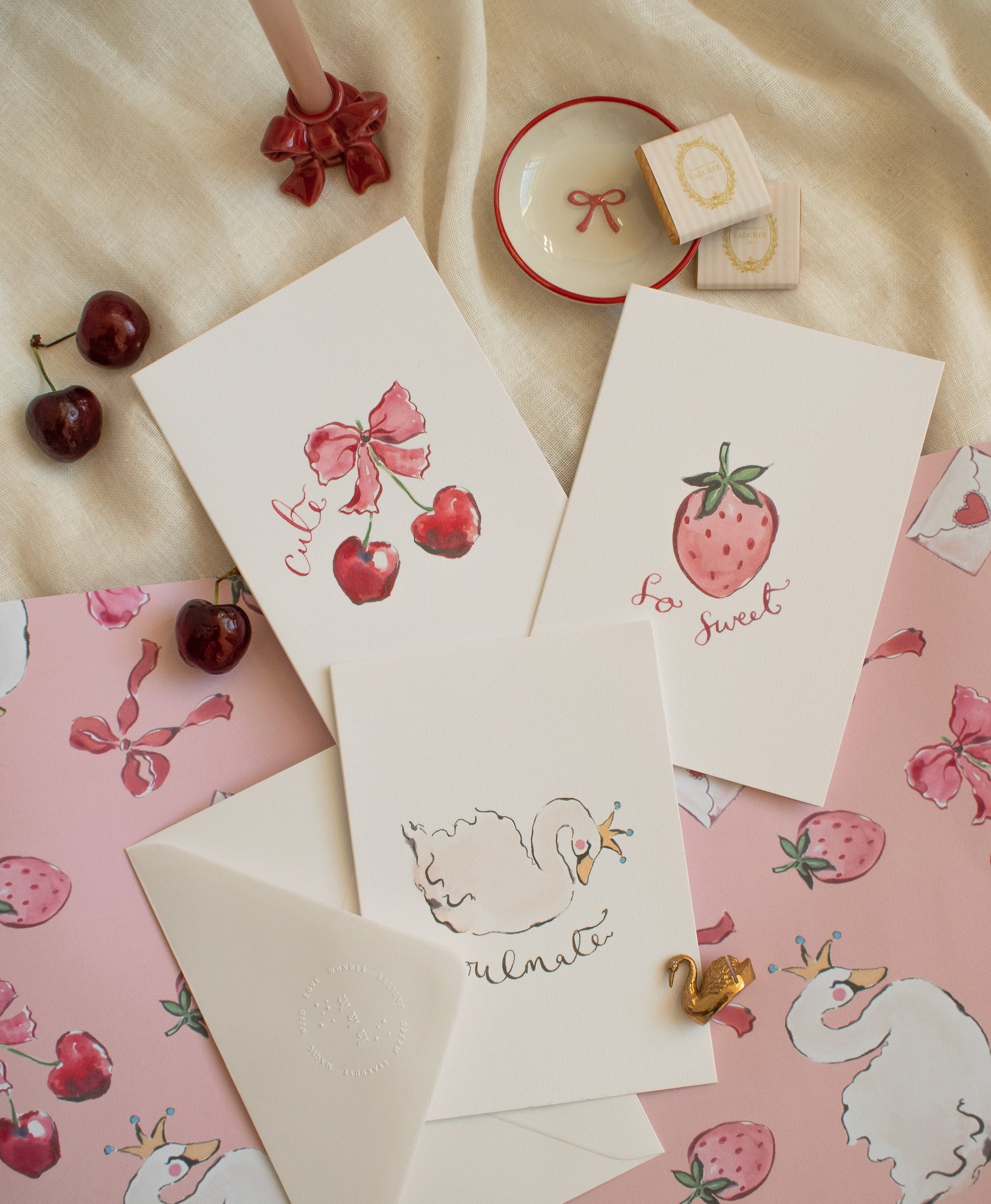 Set of cards with strawberry and cherry designs on a pink and beige background
