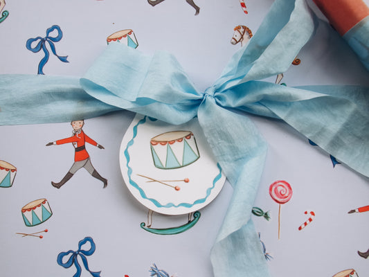Decorative gift with blue ribbon on a patterned background