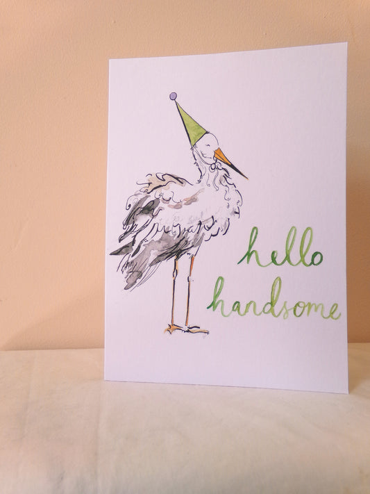 Card with a stork wearing a party hat and 'hello handsome' text on a beige background