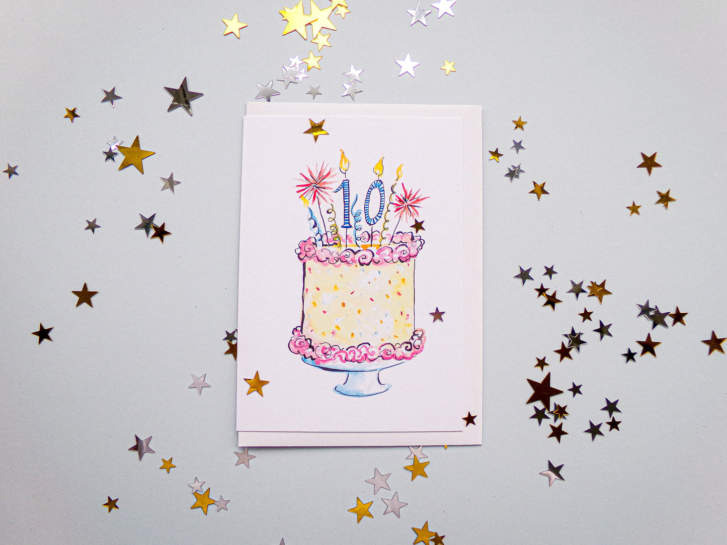 Card with a birthday cake illustration and confetti stars on a light gray background