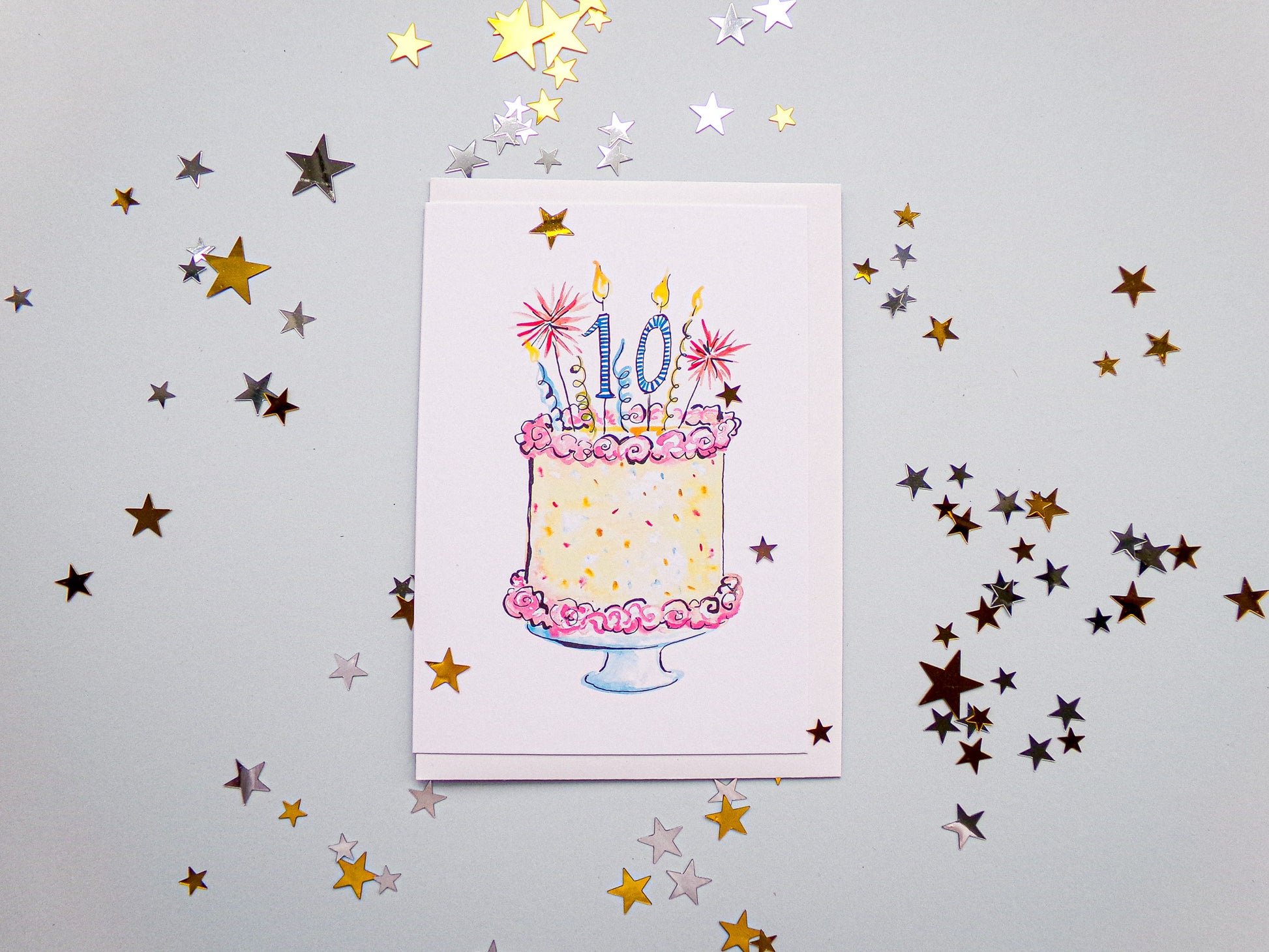 Card with a birthday cake illustration and confetti stars on a light gray background