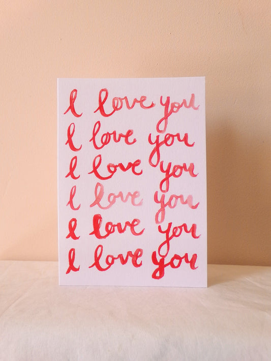 Card with 'I love you' text in red on a beige background