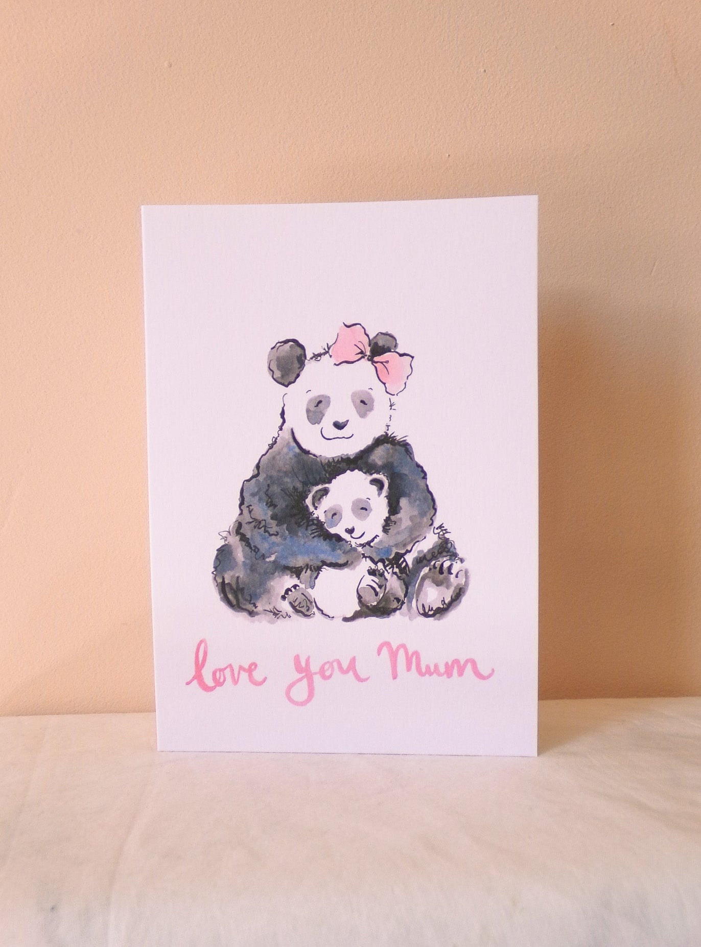 Greeting card with panda illustration and 'love you Mum' text on a beige background
