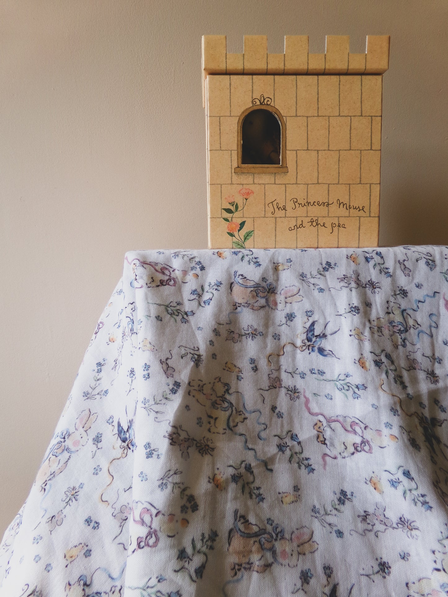 Cardboard castle model on a floral fabric background