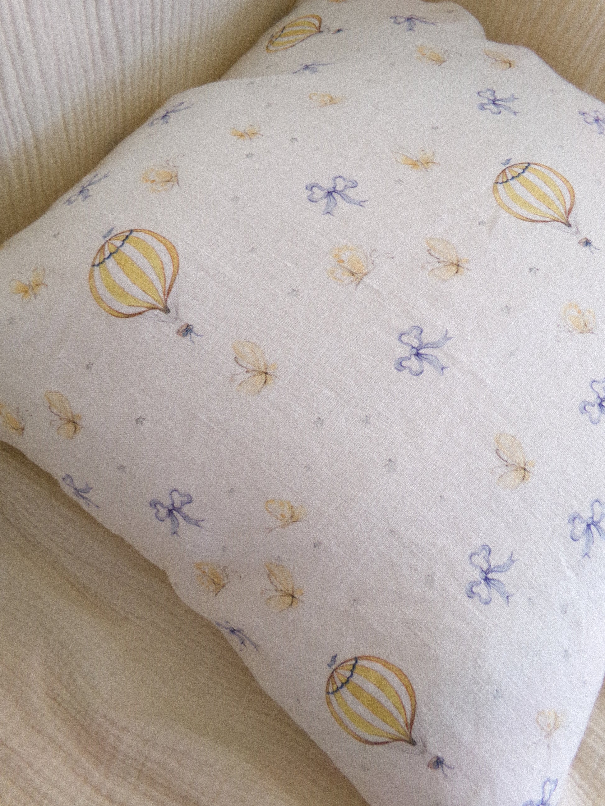 Decorative pillow with hot air balloon and flower pattern on a neutral background